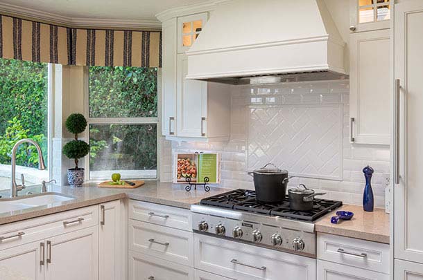 Kitchen cooking area, gas stove top, white hood - large image