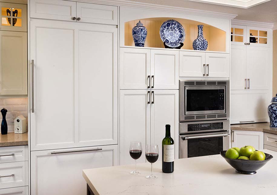 Kitchen island with wine bottle and two glasses of wine, ovens, white cabinets - x-large photo