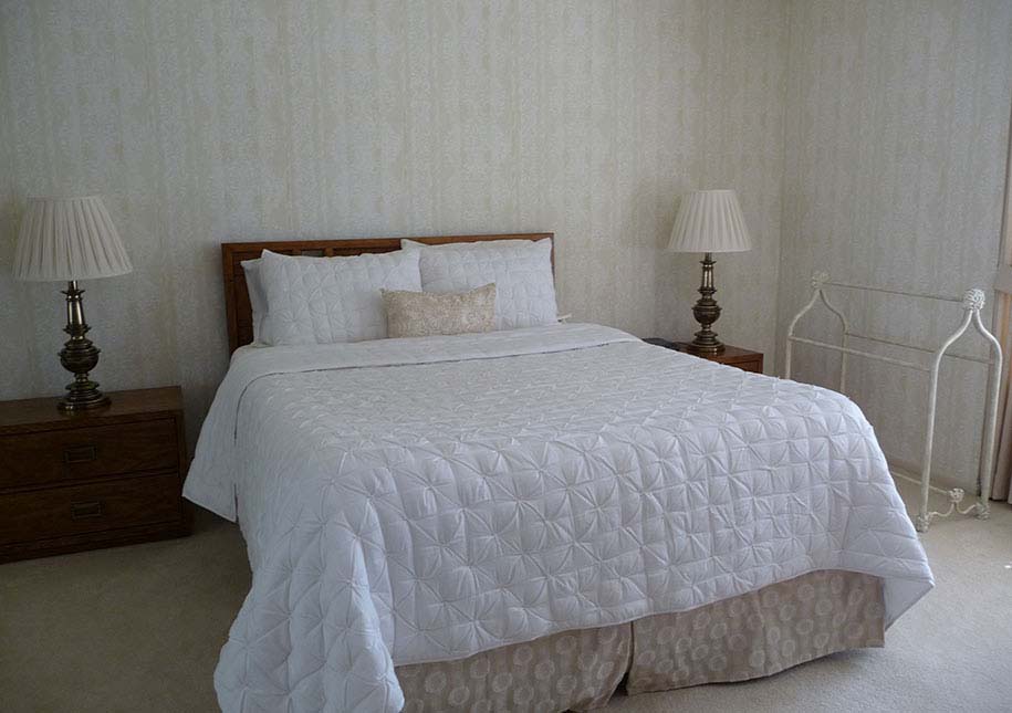 BEFORE: bedroom with wallpaper, old lamps, dark night stands - x-large photo